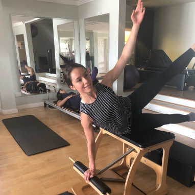 Young woman holding pose on pilates chair